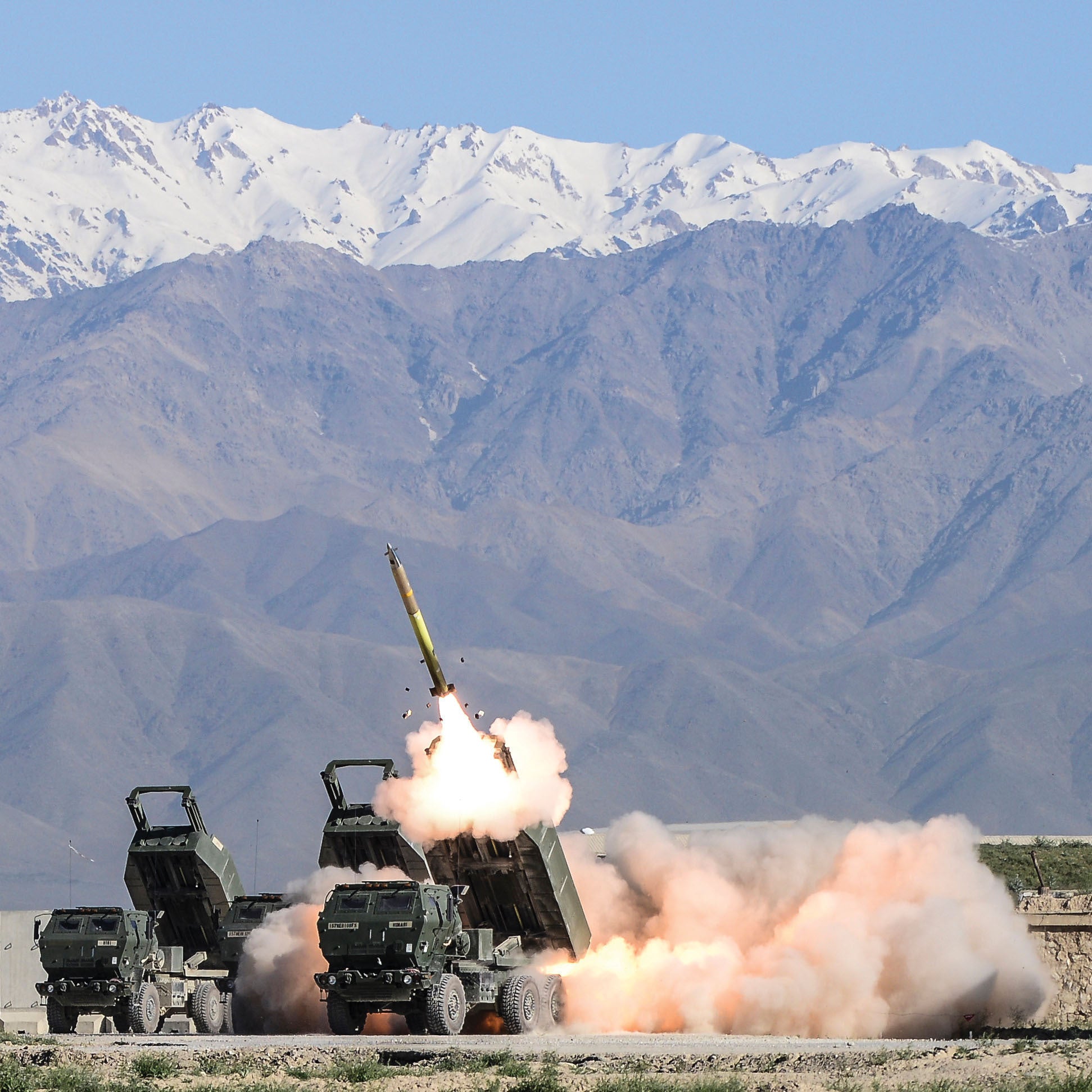 Rocket launches from launcher with mountains in background