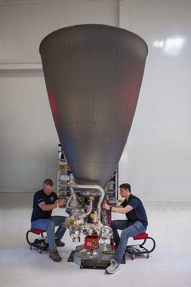 Employees inspect an engine