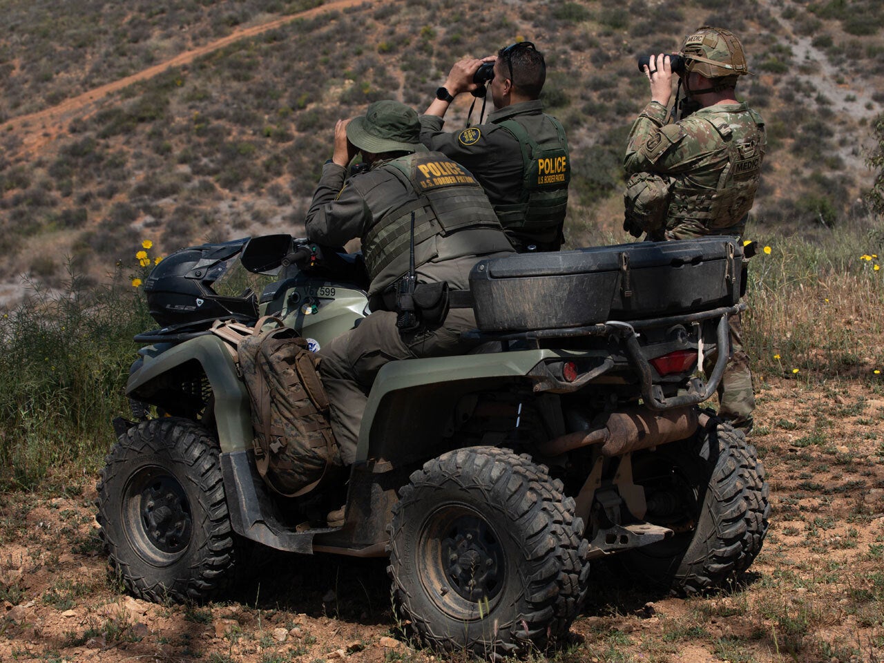Police officers on 4-wheeler scouting high desert