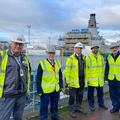 L3Harris team members stand on a dock