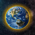 Earth from space with a yellow glow around the atmosphere