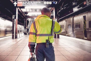Transit worker in subway station with portable radio