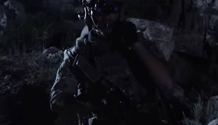 Warfighter walks through battlefield